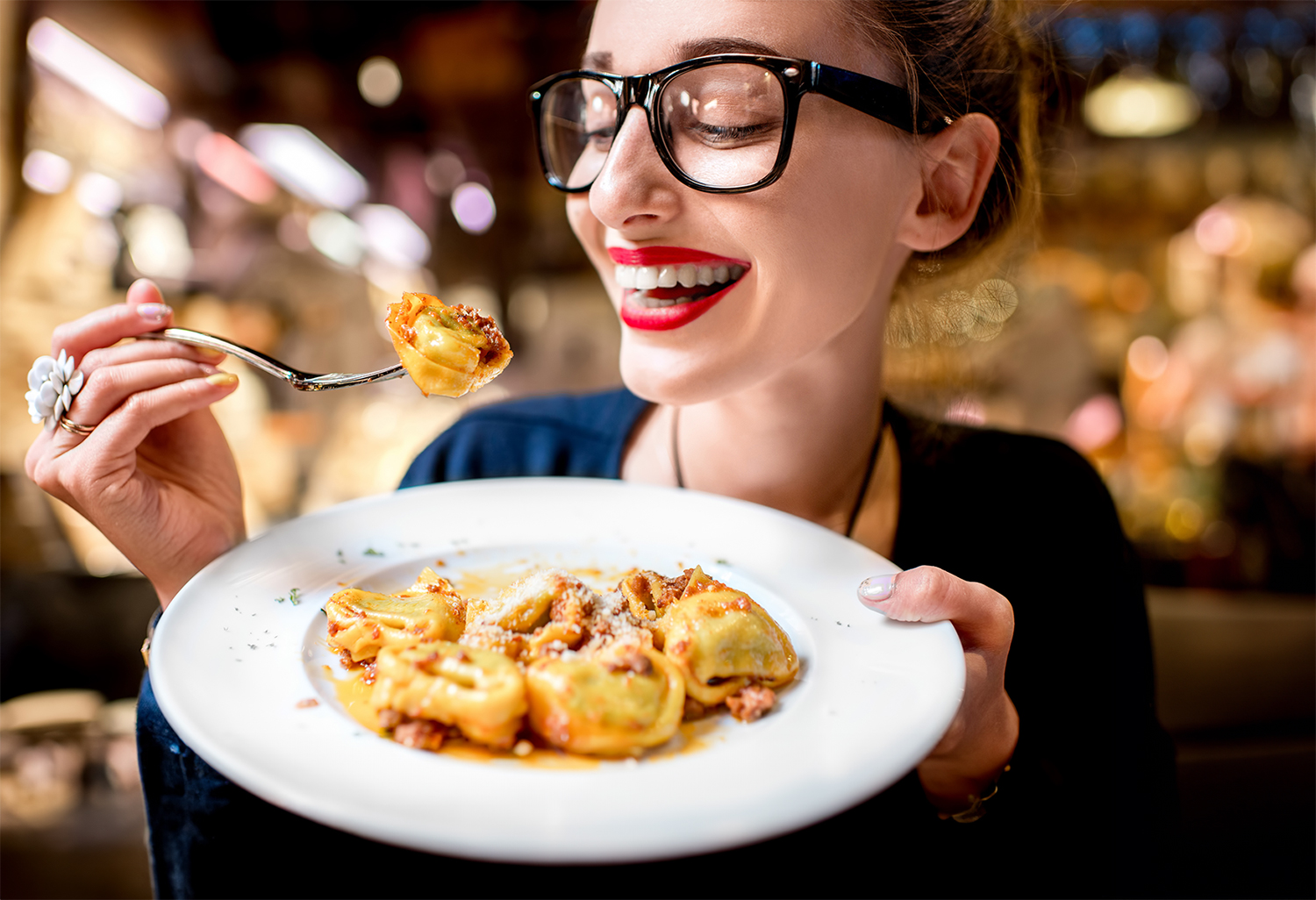 Feinkost Lüneburg: Frau genießt leckere Tortellini